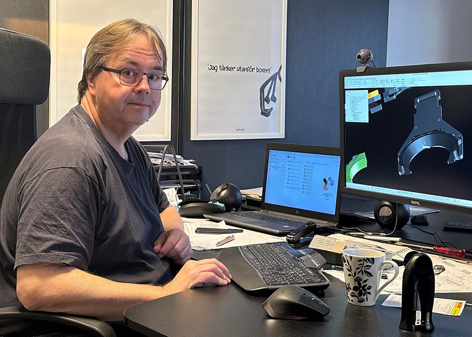 Robert Aronsson arbetar vid skrivbordet med CAD-program och 3D-modellering av en teknisk komponent.