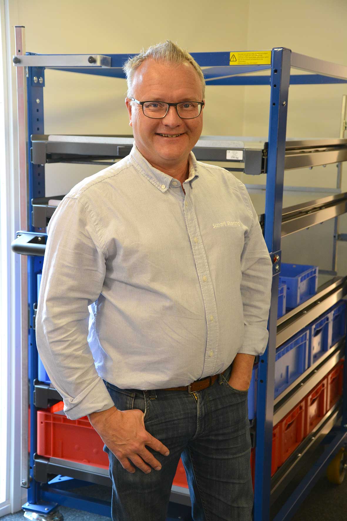 Kjell från Smart Storing poserar framför ergonomiska förvaringslösningar.