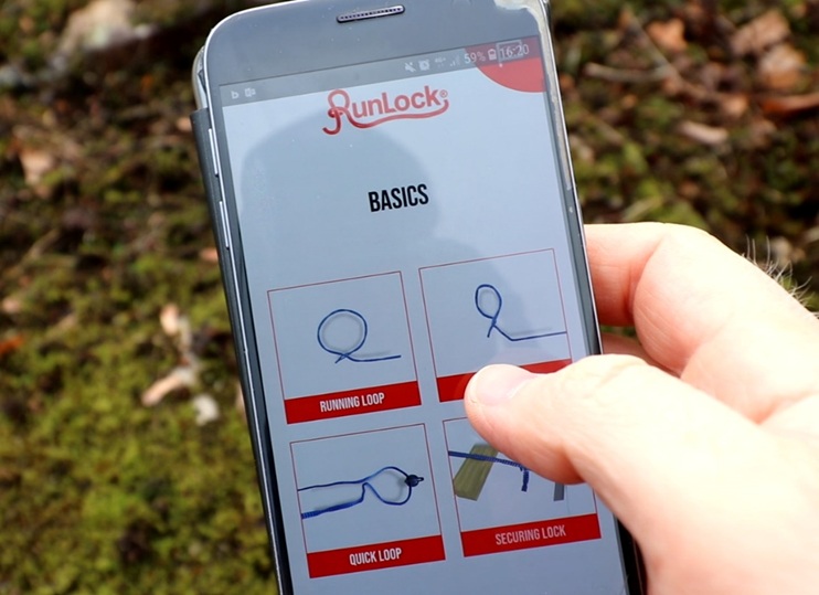 Hand håller smartphone med RunLock-appen öppen och visar knytinstruktioner.