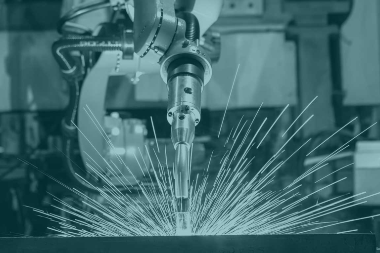 Industrirobot som svetsar och sprutar gnistor.