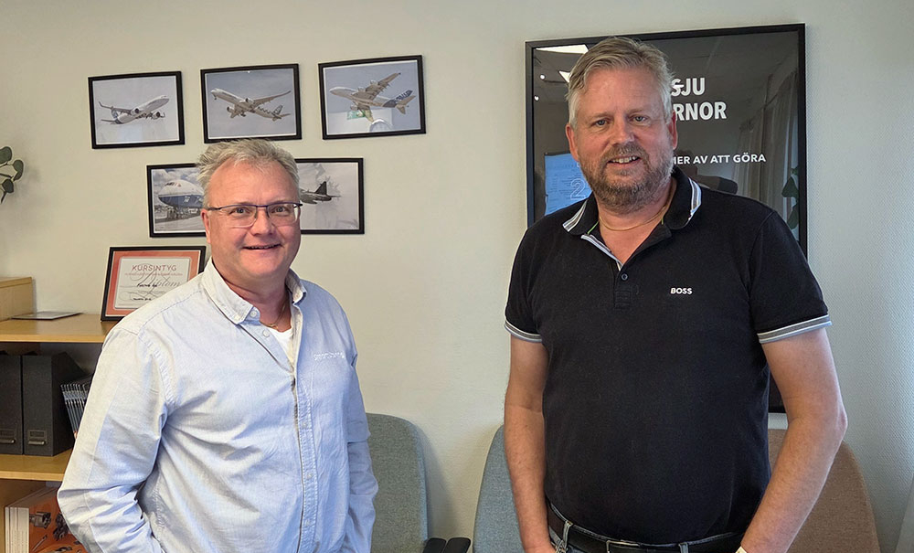 Kjell Johansson från Smart Storing och Tony Drechsel från Fortiva på kontor, stående framför vägg med flygbilder.