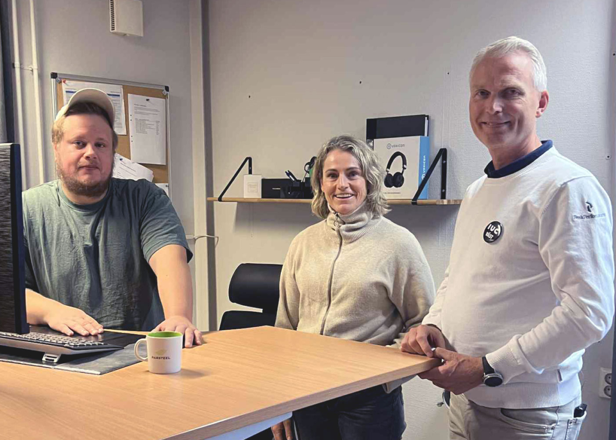 Tre personer från Parsteel och IUC Väst står vid ett skrivbord och samtalar under ett arbetsmöte om Ai och datadriven precision.