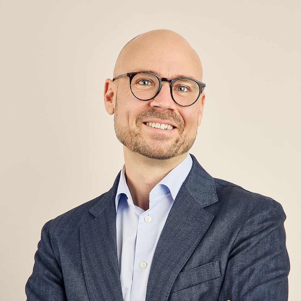 En man med glasögon, blå skjorta och blå kavaj, IUC Västs styrelse