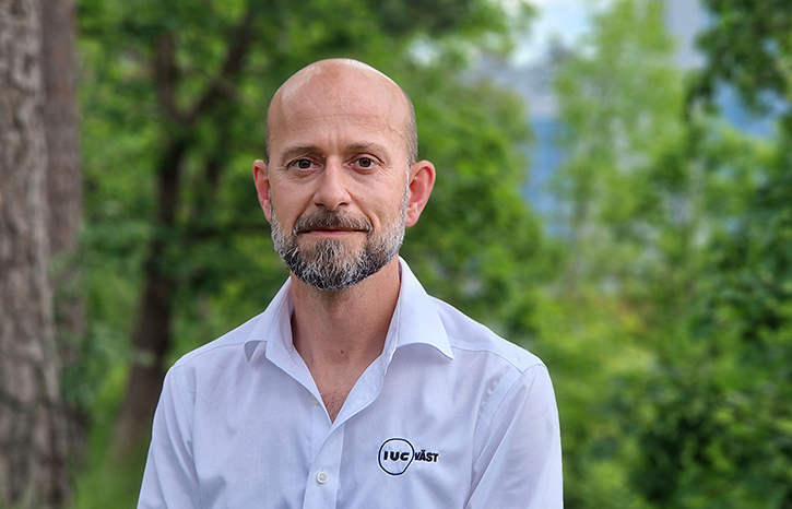 Porträtt av Daniel Walter, industriutvecklare på IUC Väst, utomhus i grönskande miljö. Förbättringsarbete och konkurrenskraft.