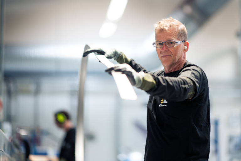 Medarbetare hanterar material i en industriell produktionsmiljö.