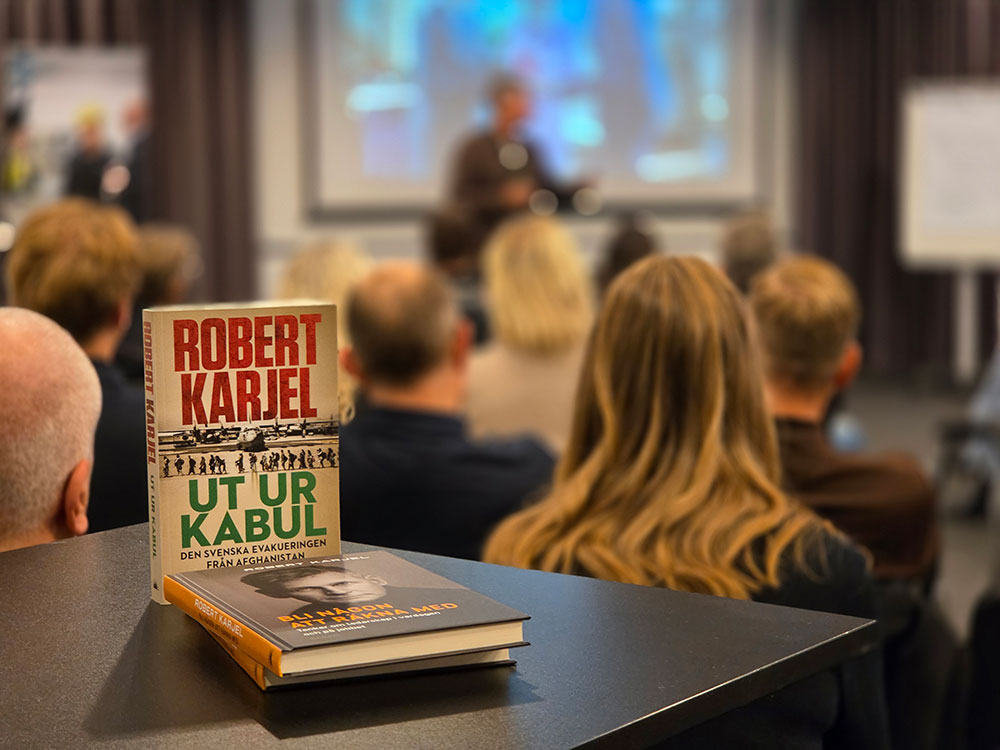 Publik under Robert Karjels föreläsning i Vänersborg, med boken ”Ut ur Kabul” i förgrunden.