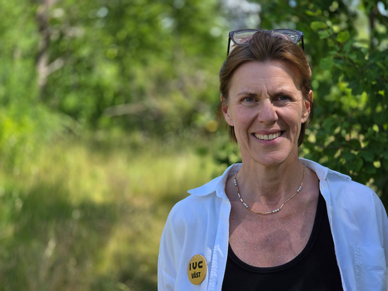 Åsa Hasslin, vd för IUC Väst, står utomhus framför en grönskande bakgrund. Industry In West. Företagsnära.